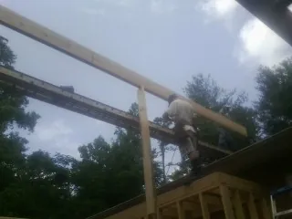 Carpenter setting a ridge beam over a new addition frame — Ice Dam Removal by Roofing Brothers in Kearsarge