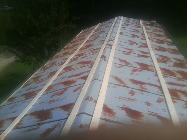 Rusted metal roof panels with new wood purlins before replacement — Storm Damage Roof Repair in Kearsarge by Roofing Brothers