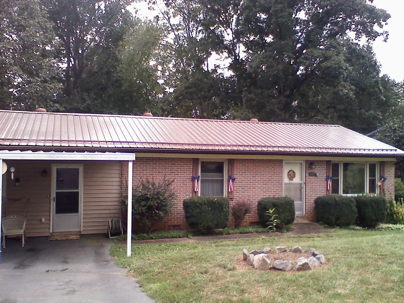 Bronze metal roof and carport on a brick ranch home — Roof Repair work by our crew in Kearsarge